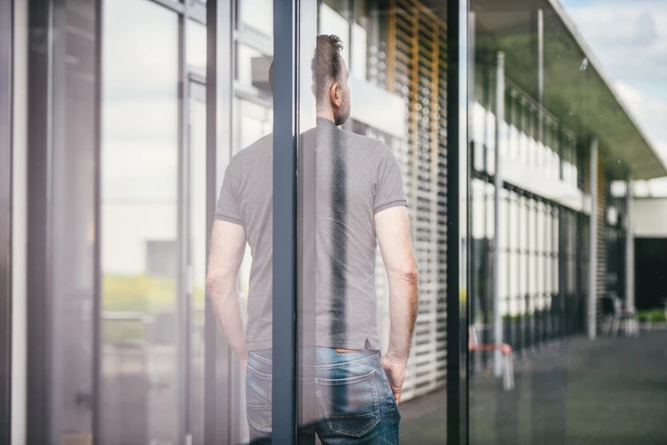 Mann steht mit R&uuml;cken zum Fenster